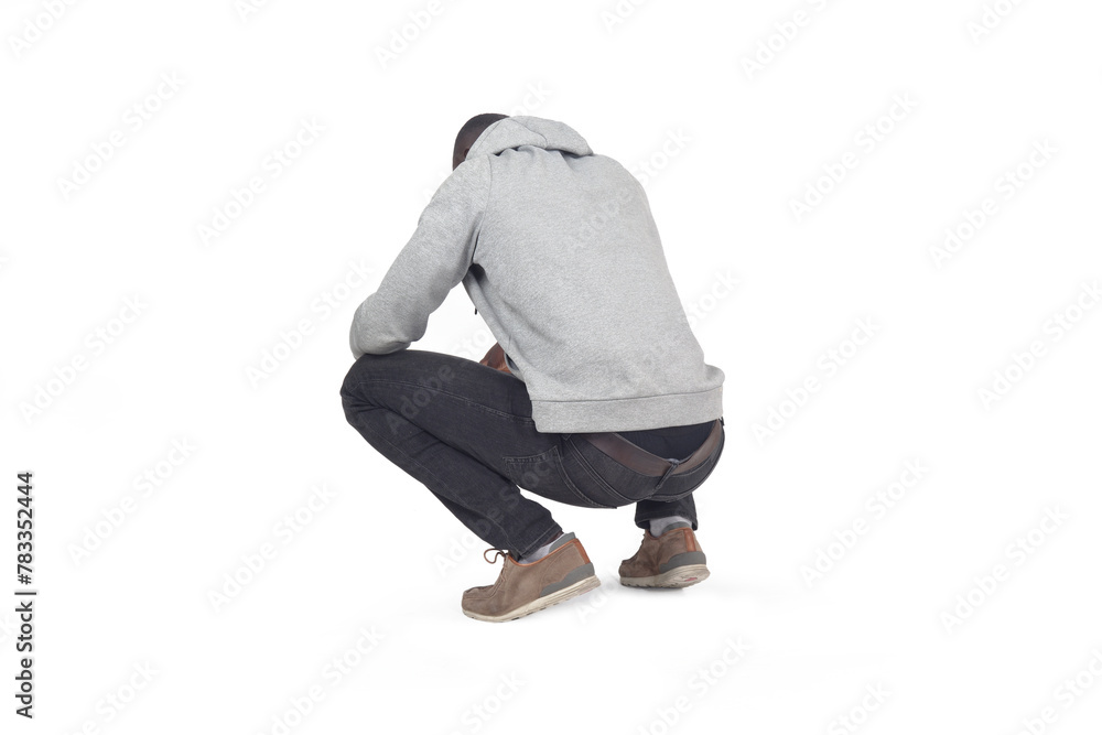 Naklejka premium side,back view of man squatting and looking down on white background