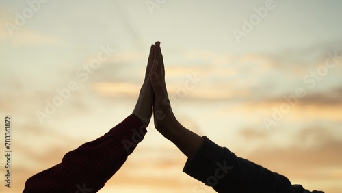 High five hands at sunset silhouette. Best friends buddies clapping each other palms in field park at dawn. Teamwork successfully completed business celebration rejoicing friendly feelings expression