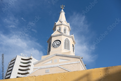 View of the Clock Tower landmark in the center of the known Walled City of Cartagena Province during a sunny day with very hot weather. photo
