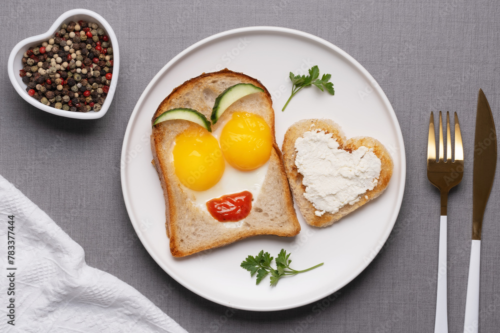 Valentine's Day breakfast with egg heart shaped and toast bread on grey background. Top view. Copy space Valentine's Day breakfast with egg heart shaped and toast bread on grey background. Top view. Copy space