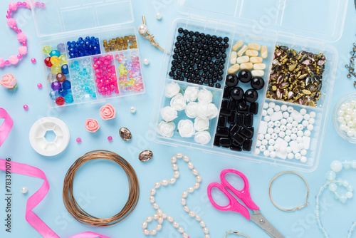 Tools and beads for making handmade jewelry on color background, top view