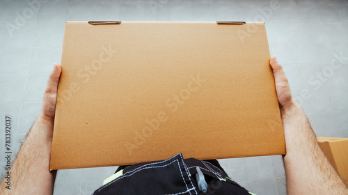 Man worker In black uniform hold big box, POV, Moving to a new apartment. Indoor at sunny day. © recpoint