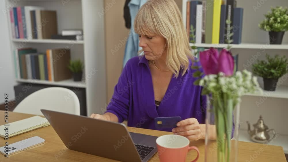 Blonde woman using laptop and holding credit card at home for online shopping Blonde woman using laptop and holding credit card at home for online shopping