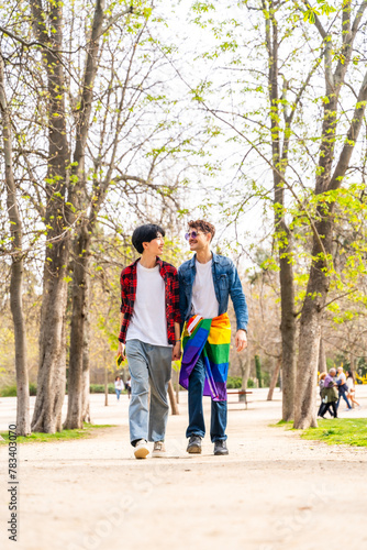 Gay male couple walking along a park