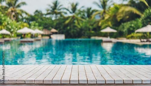 empty white ceramic mosaic table top and blurred swimming pool in tropical resort in summer banner background can used for display or montage your products