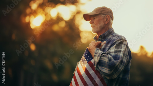 An elderly veteran holds an American flag close to his heart during a Memorial Day ceremony. The soft, natural light highlights the emotion and pride on his face, with gentle shado