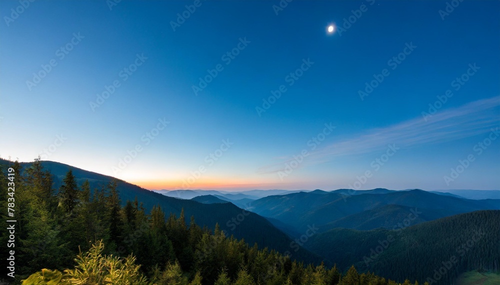 young moon over the forest in the mountains at night