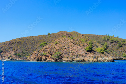 Rocky coast in the resort part of the Mediterranean or Aegean Sea. Background with selective focus and copy space