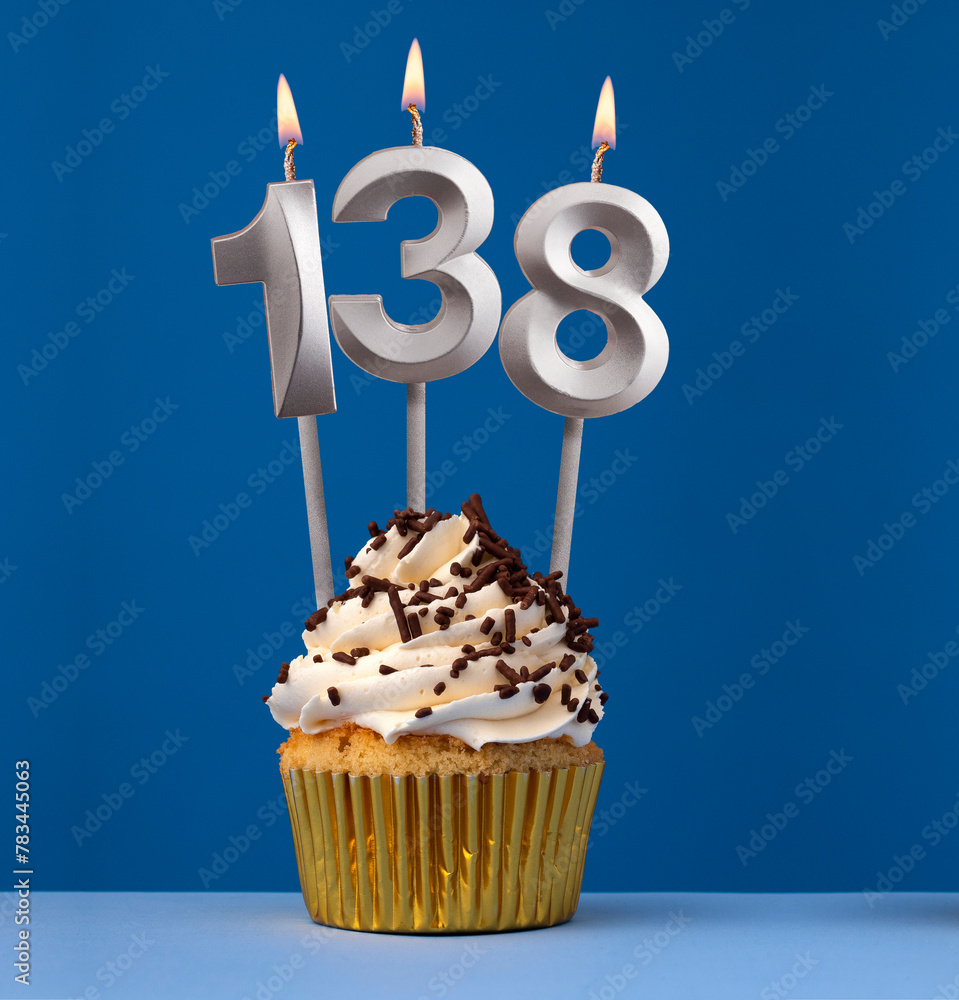 Burning candle number 138 - Birthday card with cupcake on blue Background - obrazy, fototapety, plakaty 