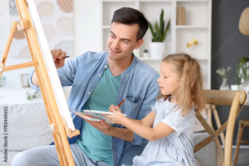 Obraz premium Cute little girl with her dad drawing at home
