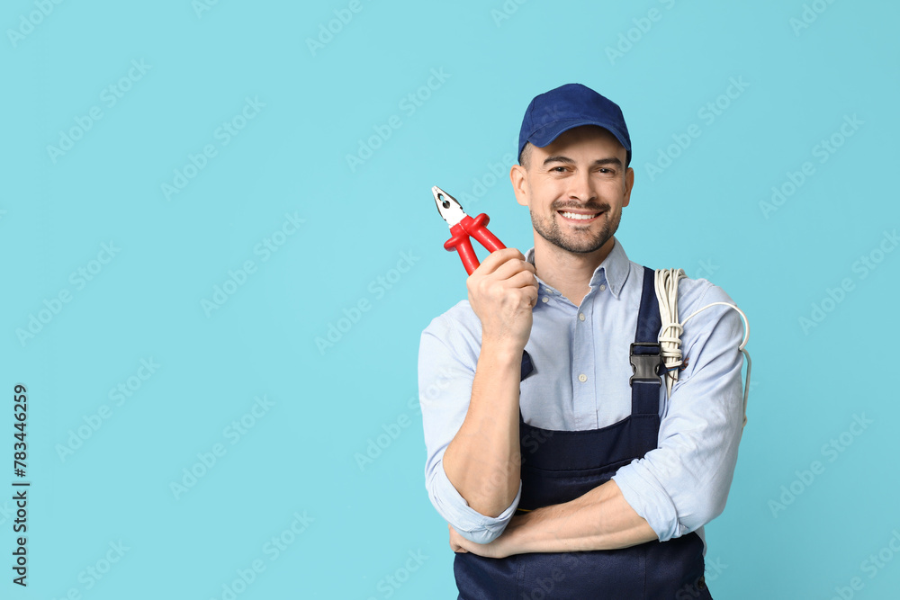 Portrait of male electrician with pliers on blue background Portrait of male electrician with pliers on blue background