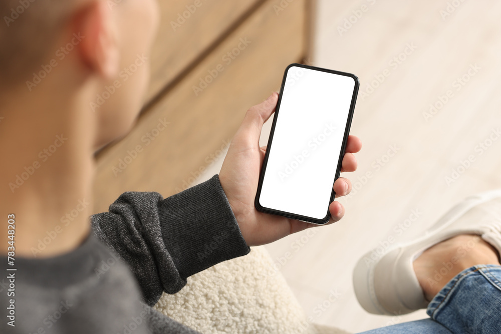 Man using smartphone with blank screen indoors, closeup. Mockup for design Man using smartphone with blank screen indoors, closeup. Mockup for design