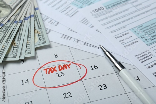 Calendar with date reminder about tax day, documents, pen and money, closeup