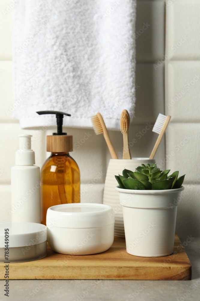 Different bath accessories and personal care products on gray table near white tiled wall Different bath accessories and personal care products on gray table near white tiled wall