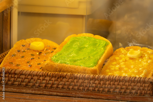 Three different types of bread with different toppings are displayed in a basket