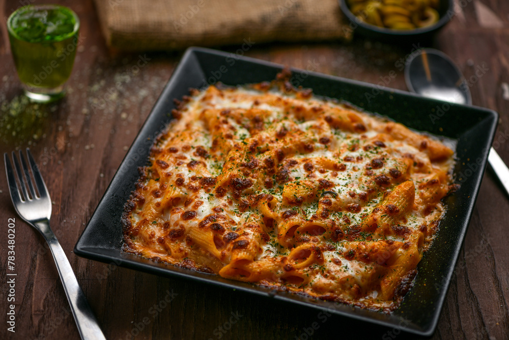 Chicken baked cheese pasta; freshly cooked pasta prepared in special pink sauce with chicken and cheese on toppings, baked and served hot Chicken baked cheese pasta; freshly cooked pasta prepared in special pink sauce with chicken and cheese on toppings, baked and served hot