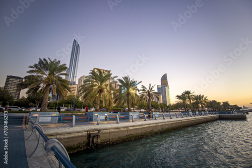 Strolling along the Abu Dhabi Corniche, a scenic waterfront promenade with stunning views of the Arabian Gulf and city's iconic skyscrapers