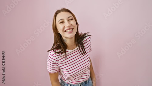 Crazy fun! young brunette girl in striped t-shirt makes wacky fish-face, puckering lips in comical jest. playful expression over isolated pink background. pure cheerful, joy-filled sillies! photo