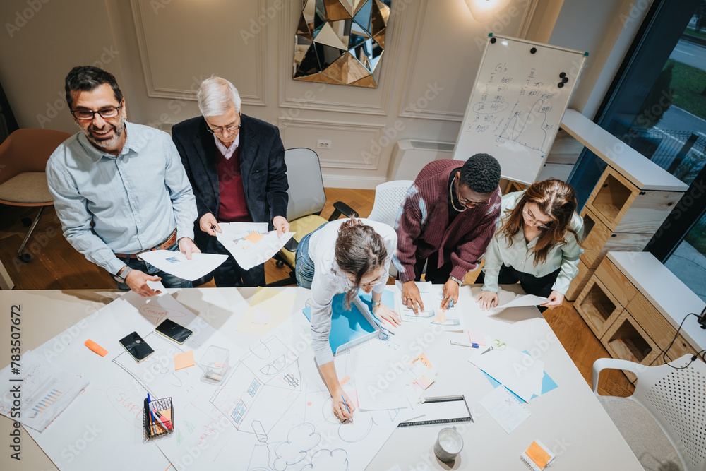 A dynamic team of multigenerational business colleagues engaged in a collaborative meeting, brainstorming and strategizing together in the office. - obrazy, fototapety, plakaty 