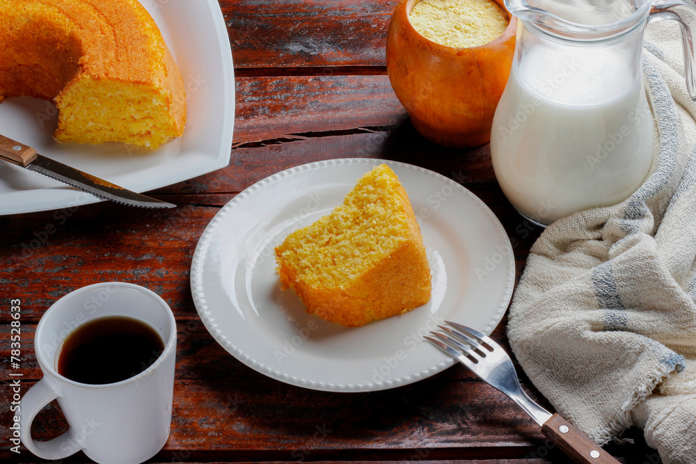 Corn Cake With Coconut white plate on rustic wooden table. Typical Brazilian party food. Corn Cake With Coconut white plate on rustic wooden table. Typical Brazilian party food.
