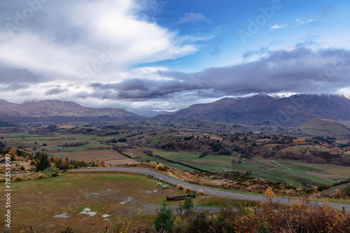 Photograph from Coronet Peak of a mountain range and a large agricultural valley on a cloudy day in Queenstown on the South Island of New Zealand