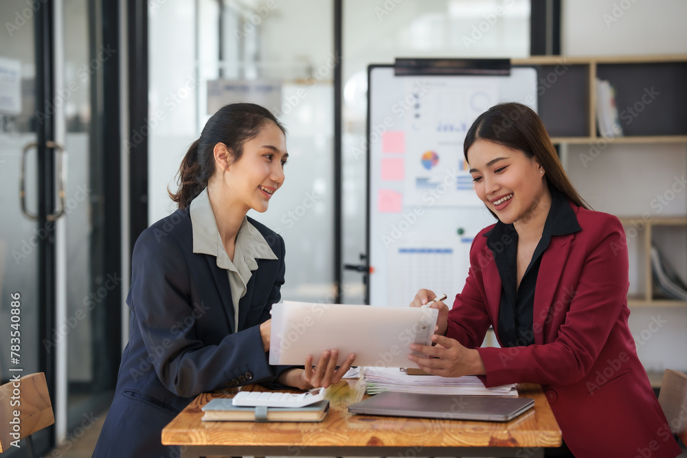 Fototapeta premium Two professional asian businesswomen talk about document in a business meeting.