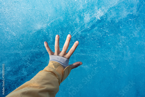 Girl's Hand Touching Cold Blue Ice berg in Iceland Winter Glacier