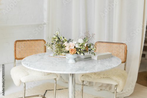 Stylish table with flowers and design book