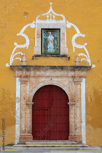 Red door of a yellow-colored old building photo