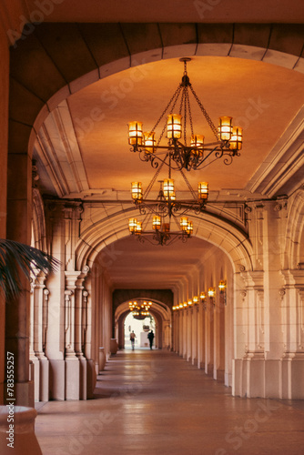 Long hallway of a building with chandeliers