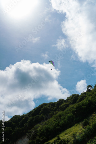 Paragliding in the blue sky over Pandawa Beach, Bali.