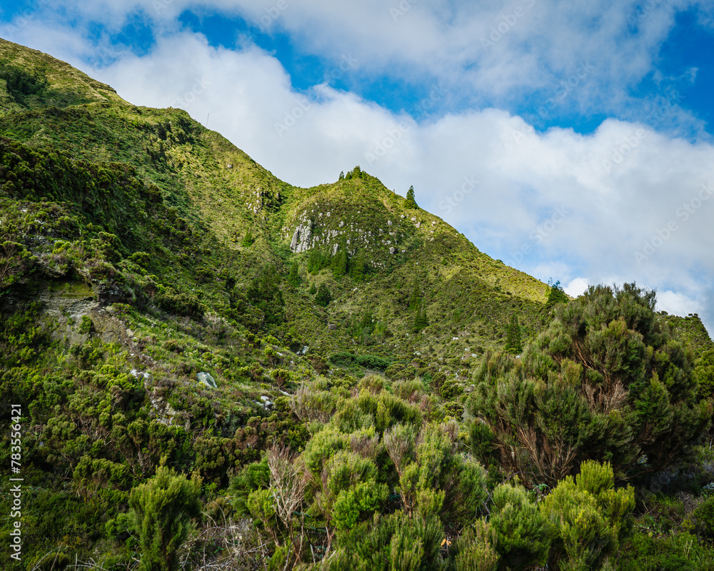 Jagged green mountains under blue cloudy skies, São Miguel