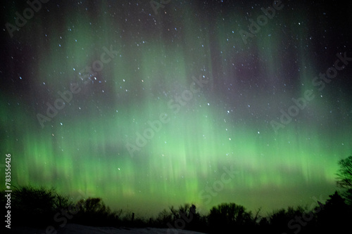 Northern lights dancing in the night sky with stars visible