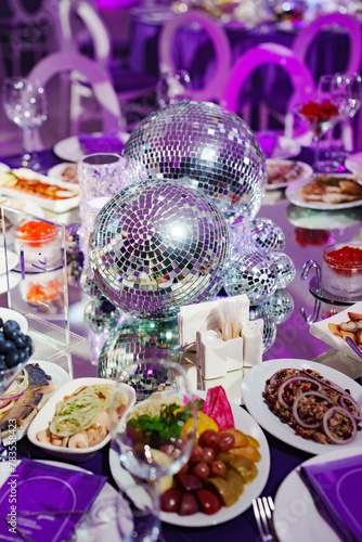 A table set for the holiday in purple in a dark banquet hall. 