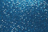 Background of blue sequins and glare in bright colours 
