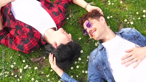 Top view of a multiracial gay couple enjoying spring lying on a park together photo