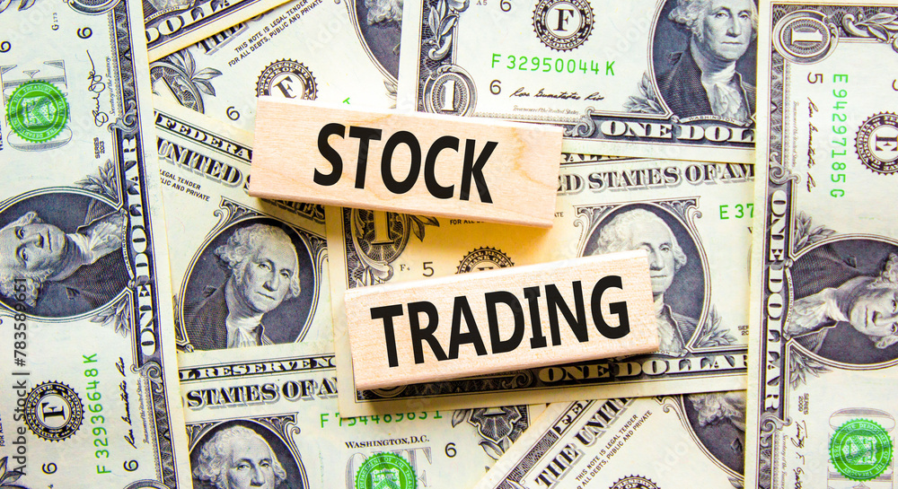 Stock trading symbol. Concept words Stock trading on beautiful wooden blocks. Dollar bills. Beautiful background from dollar bills. Business stock trading concept. Copy space.