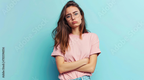 Photo of unhappy upset doubtful young woman hold hands crossed bad mood dislike , on pastel blue background photo