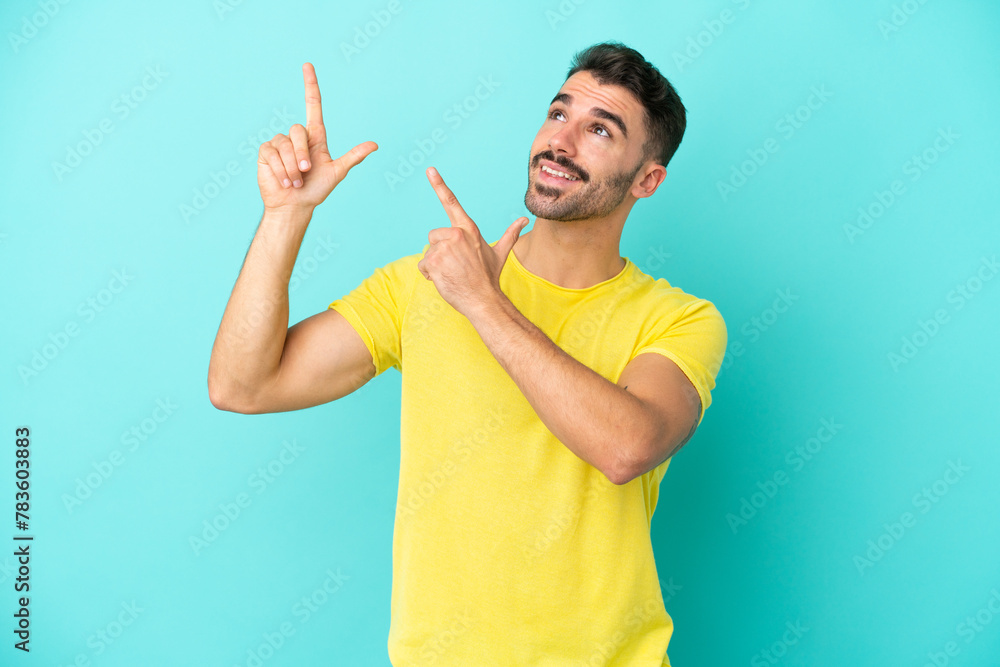 Young caucasian man isolated on blue background pointing with the index finger a great idea Young caucasian man isolated on blue background pointing with the index finger a great idea