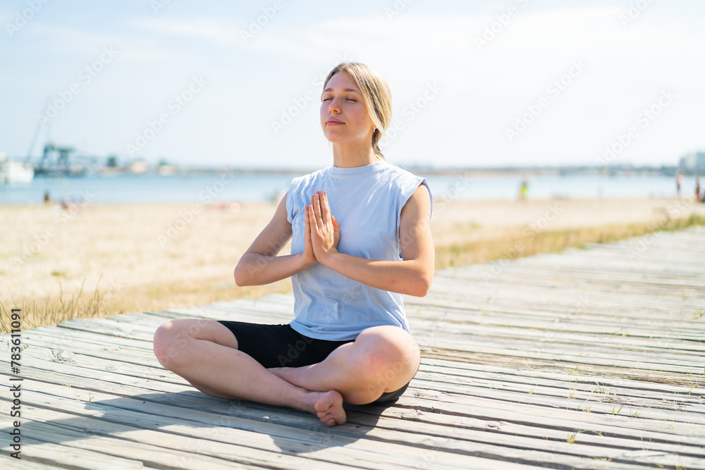 Young blonde woman at outdoors doing yoga Young blonde woman at outdoors doing yoga