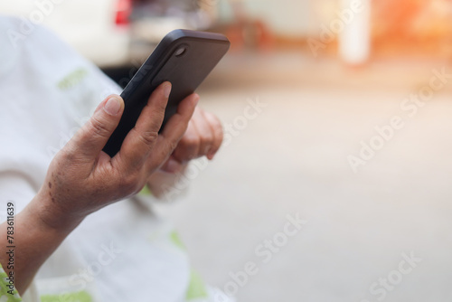 close up senior woman hand hold smartphone and swipe on screen to check about social media or reading about news feed on website for mature and lifestyle technology concept