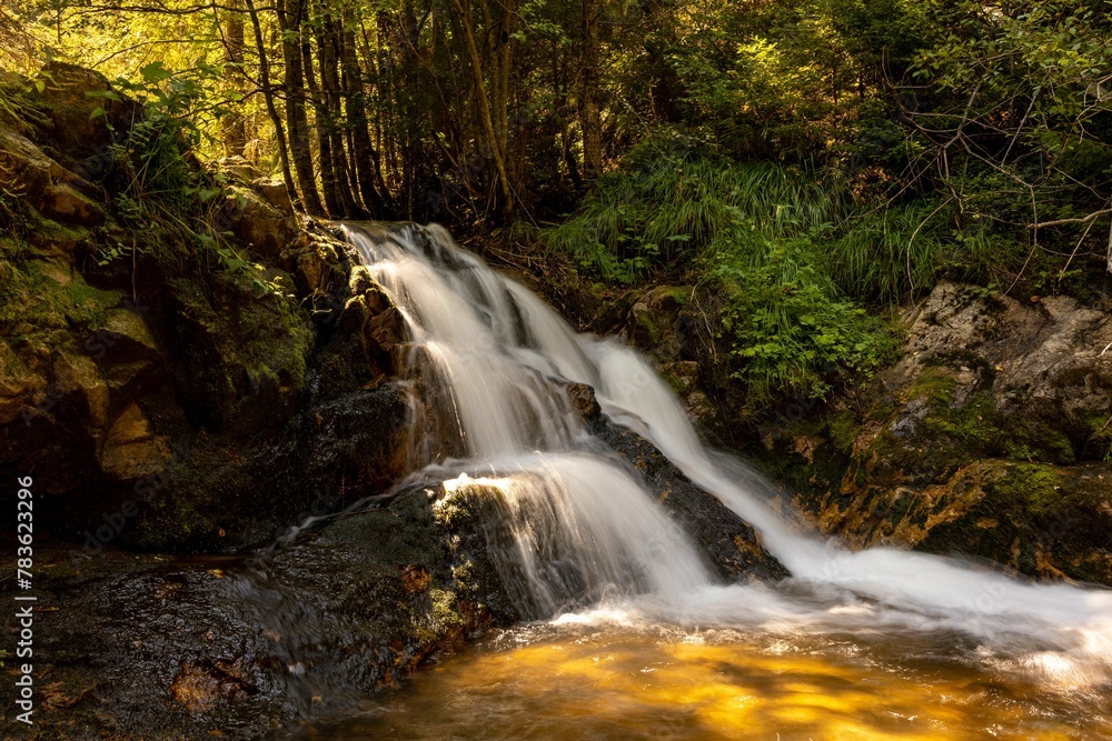 Small waterfall with long exposure in a forest on a sunny day Small waterfall with long exposure in a forest on a sunny day
