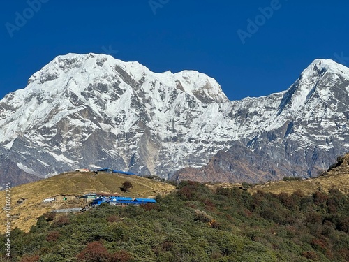 Beautiful Machapuchre Mountain with snowy peak in Nepal against the sunny blue sky photo