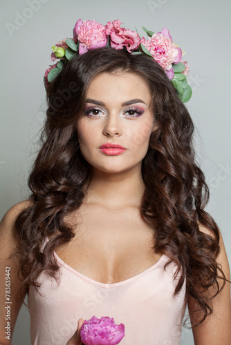 Nice young model with long curly hair, makeup and perfect healthy skin, floral blossom portrait. Spring beauty, cosmetology, facial treatment, skincare and haircare concept