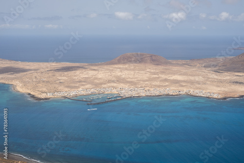 Views of the island of La Graciosa from the viewpoint of El Rio. Turquoise ocean. Blue sky with big white clouds. Caleta de Sebo. Town. volcanoes. Lanzarote, Canary Islands, Spain