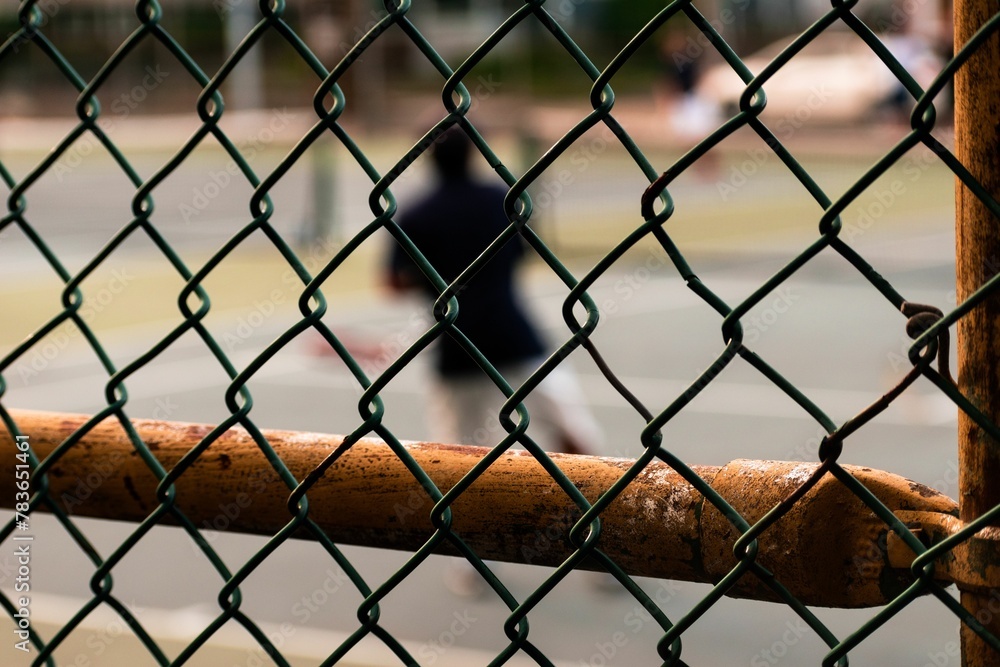 Selective focus of an Old rusty fence by a tennis court Selective focus of an Old rusty fence by a tennis court