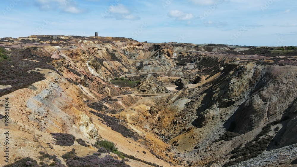 Obraz premium Aerial view of the Parys Mountain with a cloudy blue sky in the background, Wales, United Kingdom