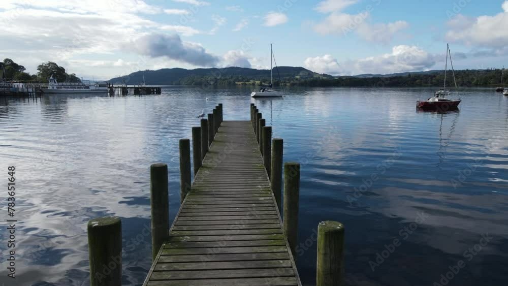 Aerial view of a wooden dock over a calm lake and a vast landscape under a clear sky Aerial view of a wooden dock over a calm lake and a vast landscape under a clear sky