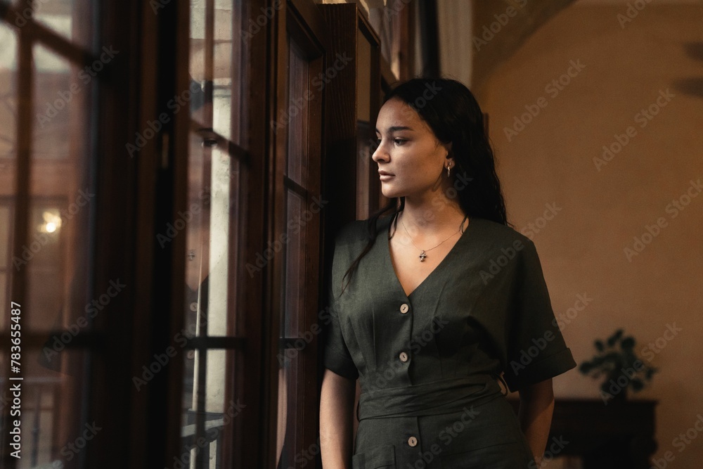 Beautiful closeup of a brunette woman next to the window