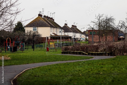 Scenic shot of an empty playground near a residential area with the overcast sky in the background